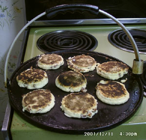 Welsh Cakes cooking on a griddle.