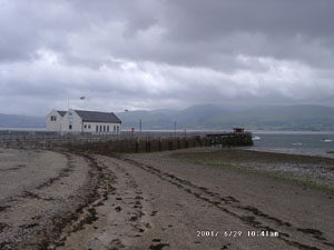 Low water at Beaumaris on a dull and windy day. View at 0941 GMT on 29 June across the Menai Strait shows the 'Blue Peter' Lifeboat Station and the cloud covered Snowdonia Mountains. Photo: © D.Perkins 2000.