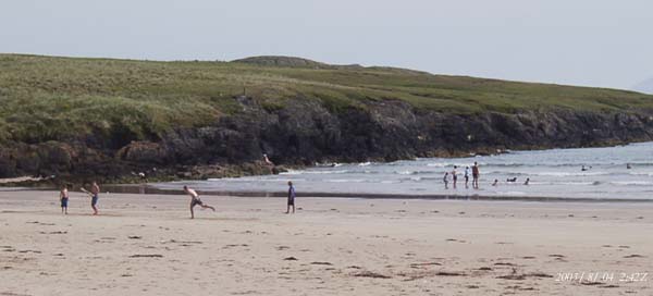 The sky lost much of its blue colour as a dust plume arrived from north Africa. Locals and holidaymakers enjoying the sea and sand at Traeth Aberffraw, including traditional cricket, on 4 August 2003