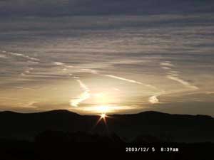 The moment of sunrise over the Carneddau Mountains photographed from Llansadwrn Weather Station on 5 December 2003. Click to see larger image. 