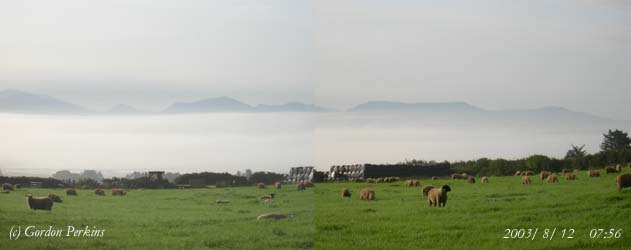 Inversion fog in the Cefni Estuary on the morning of the 12 August 2003. Mountains on the Lleyn Peninsular clear in the background. Photo: &copy; Gordon Perkins.