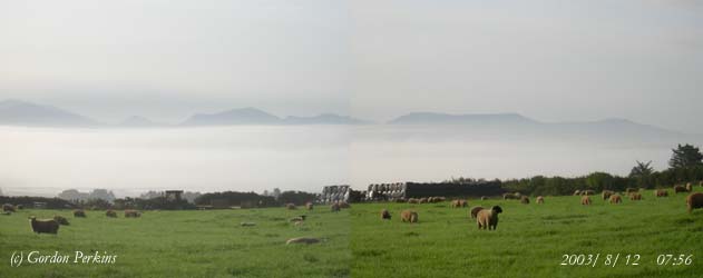 Inversion fog in the Cefni Estuary on the morning of the 12 August 2003. Mountains on the Lleyn Peninsular clear in the background. Photo: © Gordon Perkins.