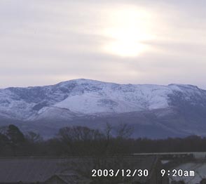 Sun obscured by thin cloud above snow on the Carneddau Mountains on 30 December 2003. Click to see larger image. 