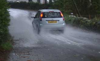 The road passing the weather station was flooded during heavy rain on 22 October 2004 . Click to see larger image. 