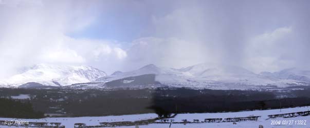 Snow showers driven by a NE'ly wind (left to right) move across the Snowdonia Mountains on the afternoon of 27 February 2004. From the left Carneddau, Nant Ffrancon Pass with the summit of Tryfan, Mynedd Perfedd and Elidir Fach with Glyders behind, Llanberis Pass and Snowdon on the right.