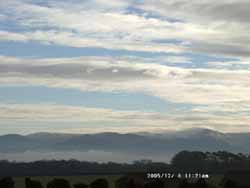 Carneddau Mountains with some fresh snow and mist in the Menai Strait.