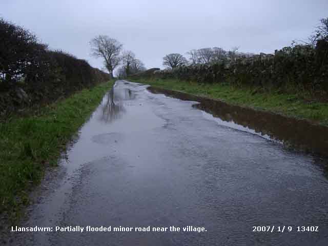 Partially flooded minor road in Llansadwrn.