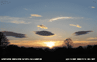 Setting sun with lee-wave cloud formation.