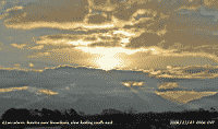 Sunrise with backlit clouds and crepuscular rays.