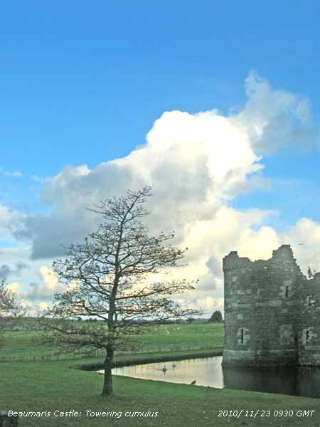 Beaumaris Castle and moat with cumulus clouds.