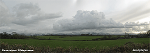 Cumulus cloud hangs over snowclad Snowdonia.