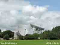 Cumulus clouds form backcloth for Jodrell Bank radio telescopes.