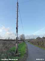 Overhead fibre optic cable in Llansadwrn.