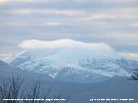 Cloud capped Snowdon covered with snow.