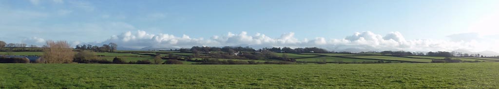 Llansadwrn view towards Gadlys and the mountains on a sunny afternoon.