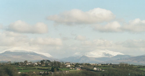 A fine afternoon on 14 April 2000 in North Wales. Snow on Snowdon (right) and Glyders (left), between is Llanberis Pass, view from Gaerwen towards Llanddaniel Fab, Anglesey. Photo: &copy; D. Perkins.