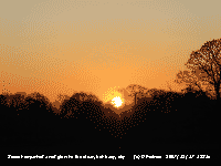 The setting sun imparted a red glow to the clear, but hazy, sky.